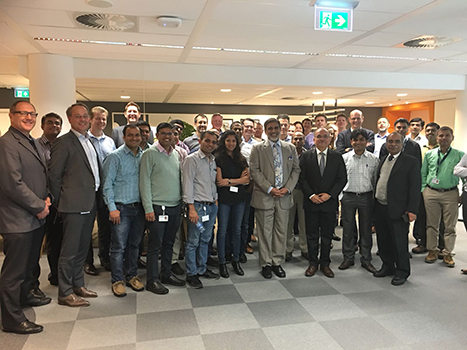 Shripad standing with a large group of people of Optravation Energyinside the office.