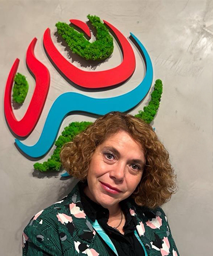 Cecilia standing in front of Optravation Energylogo on the wall.