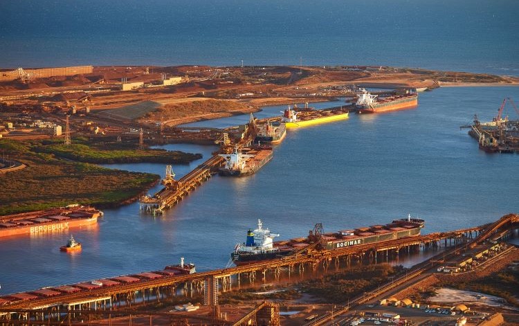 Aerial shot of a port scene, displaying ships in the water and the layout of docks and facilities.